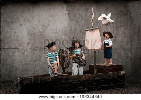 Three cute boys on pirate ship as sailors on a summer day