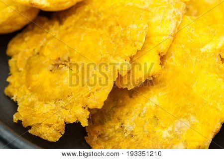 Plantain patacones on traditional black ceramic dish