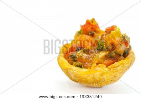 Plantain cup, made of crushed fried green plantains, filled with hogao on white background