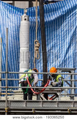 Construction workers installing pipeline on the construction site