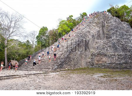 Coba Mexico - April 20 2016: Archaeological site touists climbing the Nohoch Mul pyramid