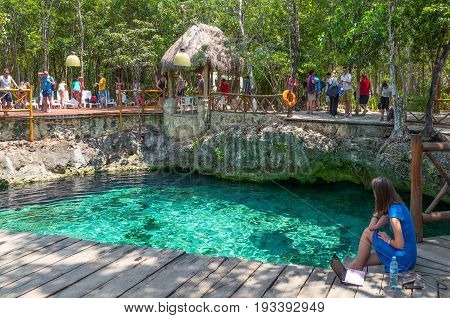 Coba Mexico - April 20 2016: Tourists bathing in the sinkhole of the archaeological site
