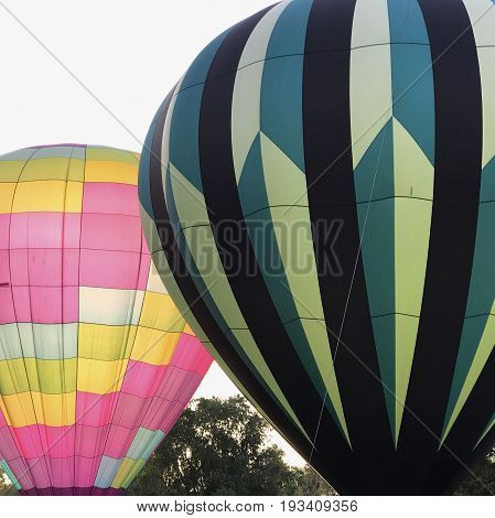 Contrasting hot air balloons ready to ascend at the 4th Annual Freedom Aloft Balloon Rally in Prineville in Central Oregon on a summer morning.