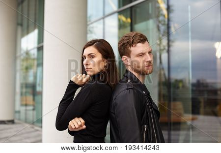 People love and relationships problem concept. Angry sad young European male and female standing on street back to back not looking at each other after conflict argument quarrel of fight