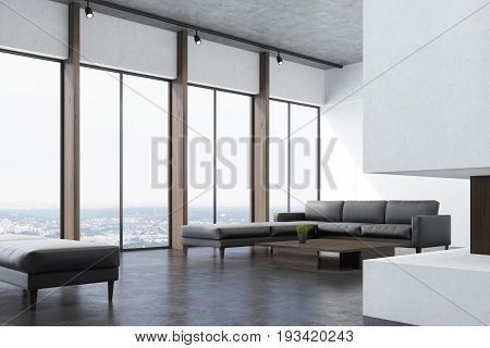 Corner of a white living room interio with a concrete floor panoramic windows a fireplace a long gray sofa and a narrow coffee table. 3d rendering mock up