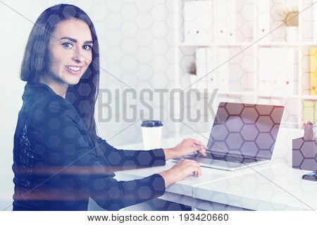 Portrait of a cheerful young businesswoman smiling while sitting at her workplace in a white office. Concept of a business career. Toned image mock up double exposure