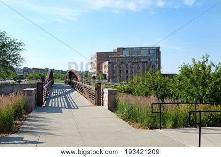 SIOUX FALLS, SOUTH DAKOTA - JUNE 21, 2017: Riverwalk footbridge along the Big Sioux River. Parks, hotels, restaurants and footbridges, line the popular area along the cities revitalized downtown.