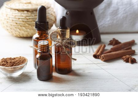 Composition with bottles of cinnamon oil on wooden background