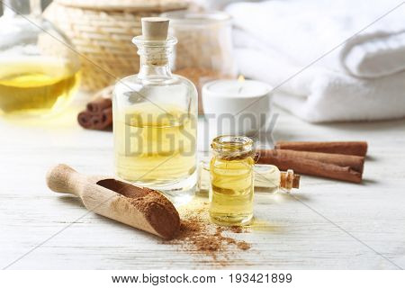 Composition with bottles of cinnamon oil on wooden background