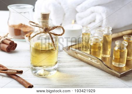 Composition with bottles of cinnamon oil on wooden background