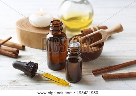 Composition with bottles of cinnamon oil on wooden background