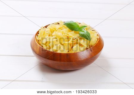 bowl of quadretti - square shaped pasta on white wooden background
