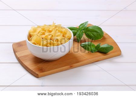 bowl of quadretti - square shaped pasta on wooden cutting board