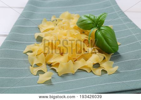 pile of quadretti - square shaped pasta on grey place mat - close up
