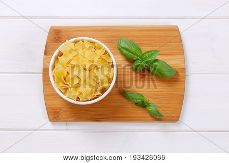 bowl of quadretti - square shaped pasta on wooden cutting board