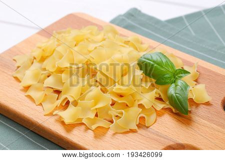 pile of quadretti - square shaped pasta on wooden cutting board - close up