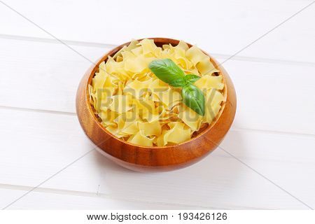 bowl of quadretti - square shaped pasta on white wooden background