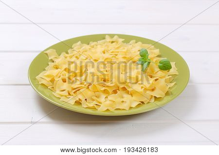 plate of quadretti - square shaped pasta on white wooden background