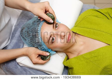 Spa treatment. Facial massage with jade stones. Alternative medicine. Massage of forehead zone. Guasha