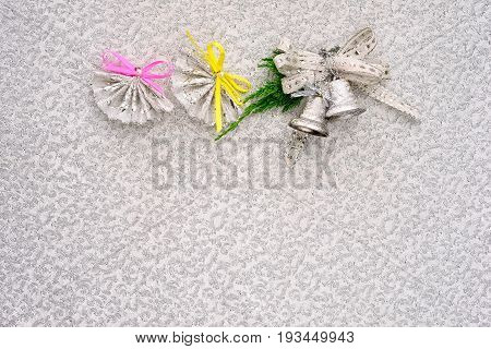 christmas and new year congratulation background in silver colors. row of two fans and bells with bow with copy space for your text below.