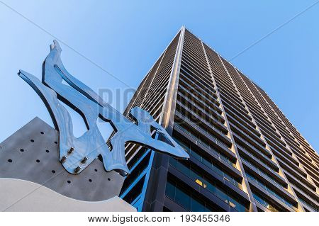 Atlanta, Georgia, USA - December 29, 2016: Bottom view of the abstract sculpture and office skyscraper on the background of clear sky