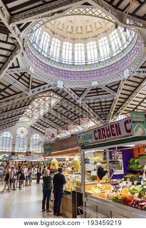 VALENCIA, SPAIN - JUNE 12, 2017: Vegetable stall with people at the Mercado Central of Valencia, Spain