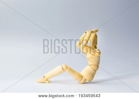 Wooden figure doll with sit up for health on white for exercise training and helth concept.