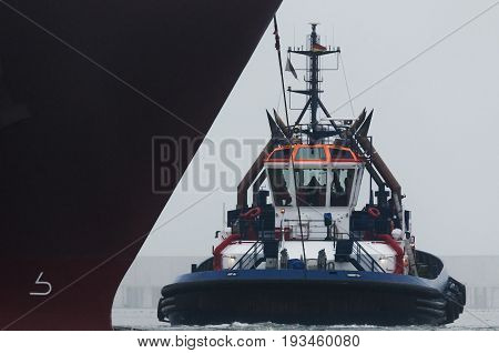 TUG AND GAS TAKER - The tug  maneuver at the bow of a large ship
