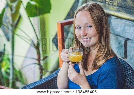 Young Beautiful Redhead Woman Sitting In A Cafe Drinking A Delicious Morning Ginger Tea In A Cafe
