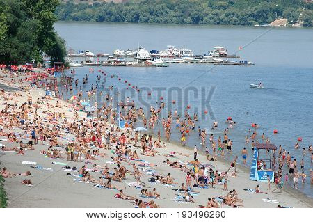 Novi Sad Serbia - July 31 2008: People enjoy swimming walking and sunbathing in the friendly environment on a beach called Strand on a Danube river. / Summer on the river Danube in Serbia