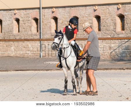 Father help his daughter before equine competition