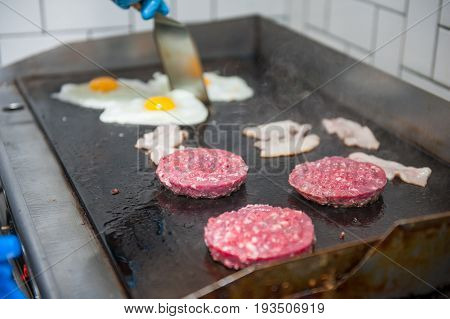 Chief Cook Preparing Fresh Burger In The Kitchen. Burger Restaurant Menu Cooking Process. The Chief