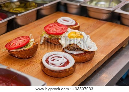 Chief Preparing Fresh Burger In The Kitchen.burger Restaurant Menu Cooking Process. Burger Ingridien