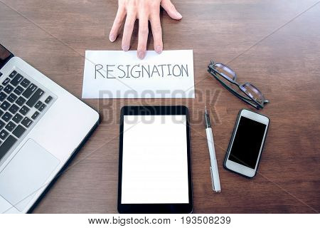 Image of businessman hand sending a resignation letter to executive boss with glasses pen and laptop on a wooden table Change of job unemployment resign concept.