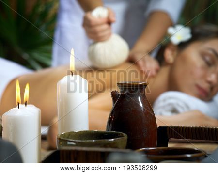 portrait of young beautiful woman in spa environment. focused on candles.