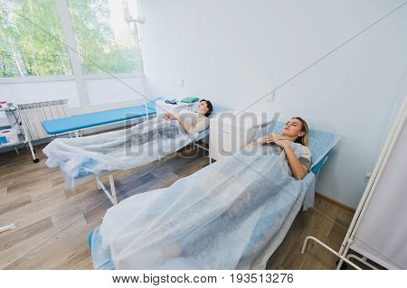 Female patient sleeping in medical bed at the hospital ward.