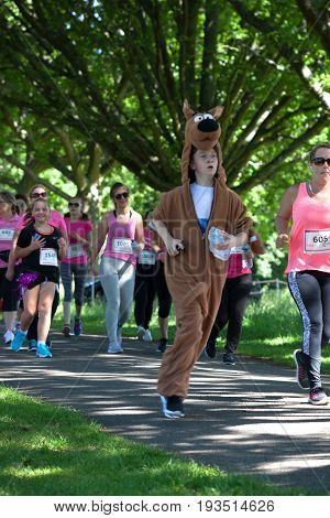 SOUTHAMPTON UK - July 2 2017: Race for Life women and children run and walk to raise money for Cancer Research charity in Southampton UK. Boy dressed as Scooby Doo dog running race.