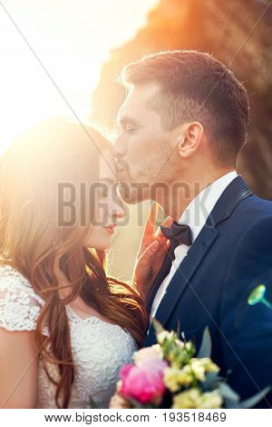 Beautiful couple in love kissing in close-up. Wedding couple kissing at sunset and waves of love and tender feelings. Couple in love on vacation. Wedding ceremony outdoors perfect couple. Blurred