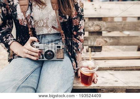 Stylish Hipster Woman Holding Lemonade And Old Photo Camera. Boho Girl In Denim And Bohemian Clothes