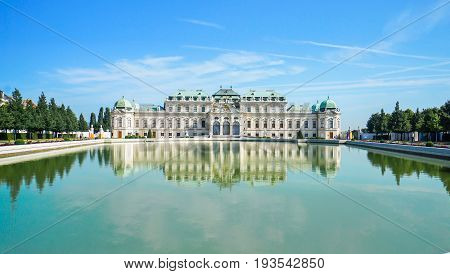 Beautiful view of famous Schloss Belvedere with a reflectant pool and blue sky in Vienna Austria