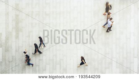top aerial view of people walk and stand on pedestrian walkway.
