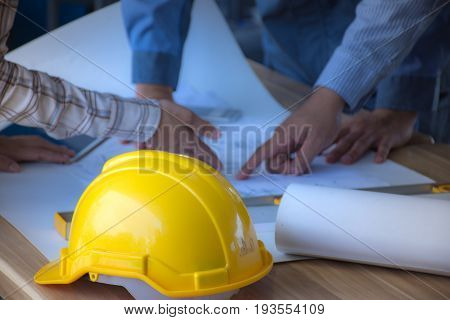 Safety helmet placed on a meeting table engineering team. /Selective focus at safety helmet.