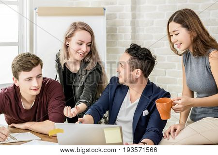 Multiethnic college students discussing group work together - education concept