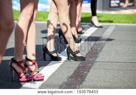 Girls legs in high heels on the starting grid of motor racing and Motorsport