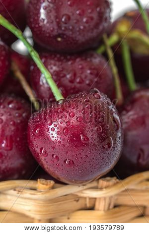 Sweet red cherries with water drops in basket macro