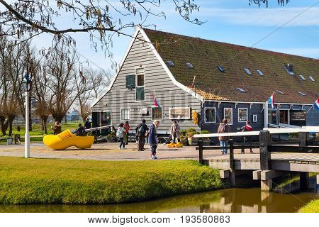 Zaanse schans, Netherlands - April 1, 2016: Wooden shoes, clogs or klompens museum, Zaanse Schans village, Holland, people around