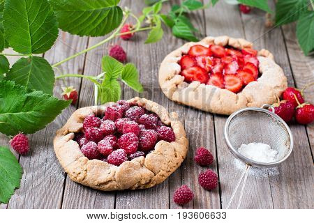 Homemade galette with summer berries on a wooden background