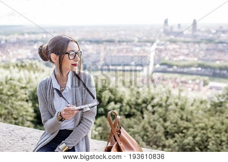 Young woman with photocamera enjoying great view on Lyon city during the morning in France