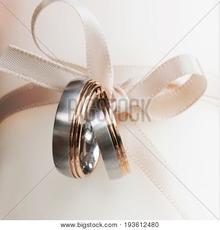 Wonderful wedding rings with a tender loop on a bright background