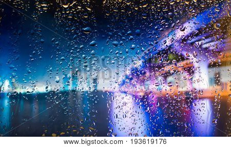 bridge A view of the city from a window from a high point during a rain. Rain drops on glass. Focus on drops